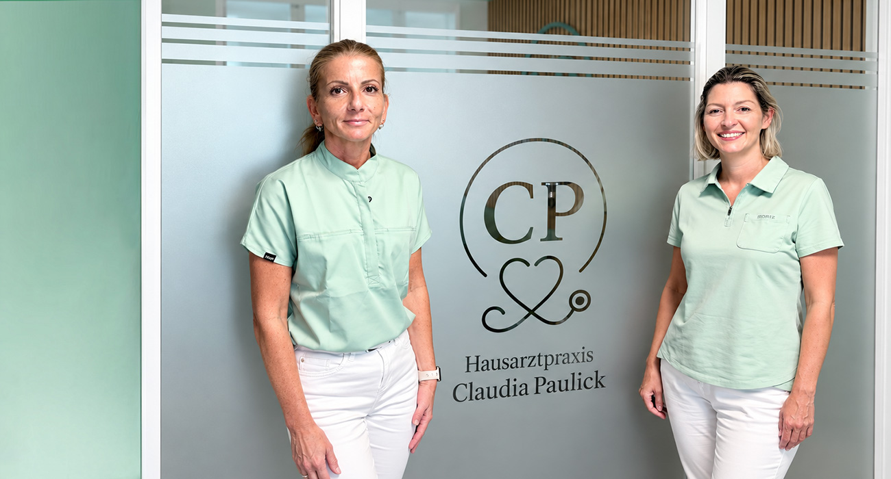 Claudia Paulick mit Schwester Steffi vor einer Glaswand mit Logo
